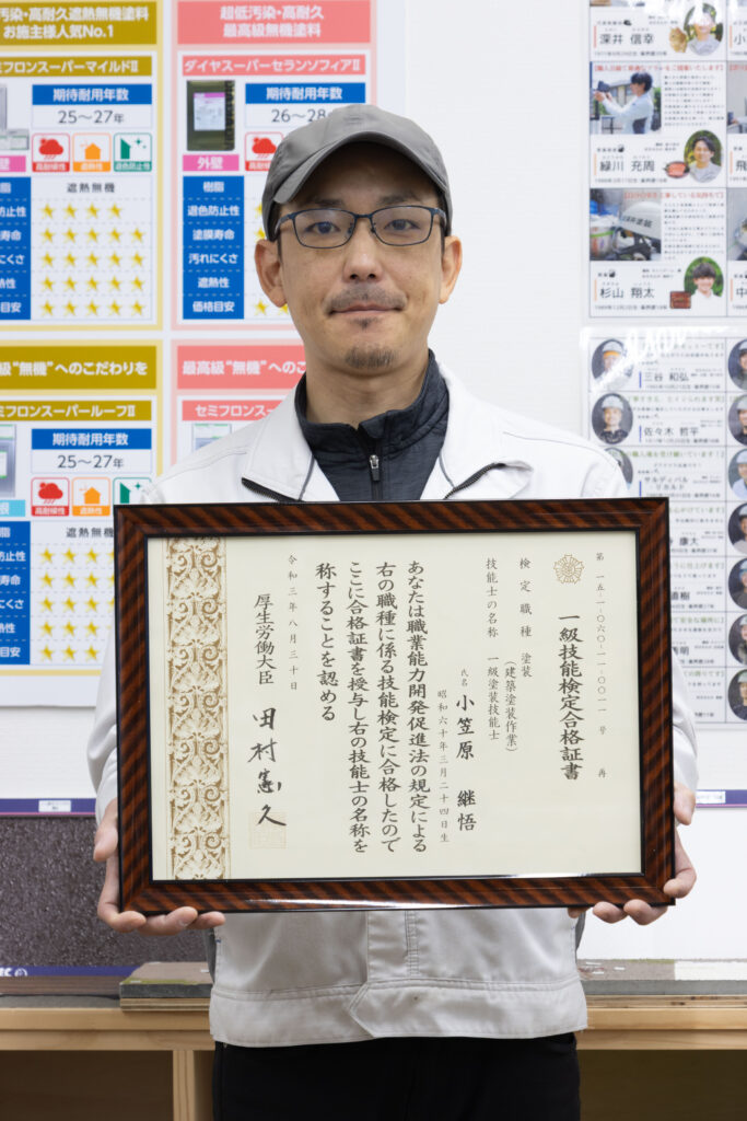 一級塗装技能士の証書と店長小笠原の写真