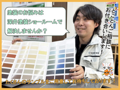 深井塗装スタッフが塗料カラーサンプルをひろげてショールームでお悩み解決しませんか？と問いかけている